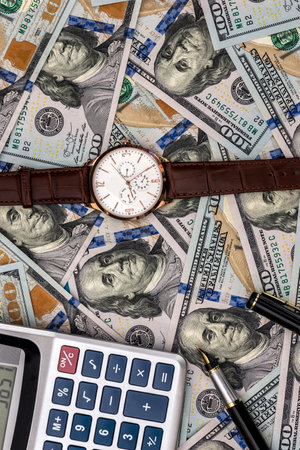 conceptual clock, calculator on the background of dollar billsの写真素材