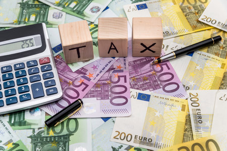 tax on wooden cubes with euro bills calculatorの写真素材