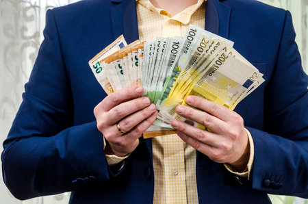The businessman holds the euro in hands.の写真素材