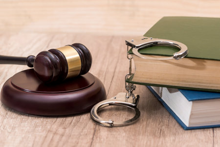 gavel with book and handcuff on desk
