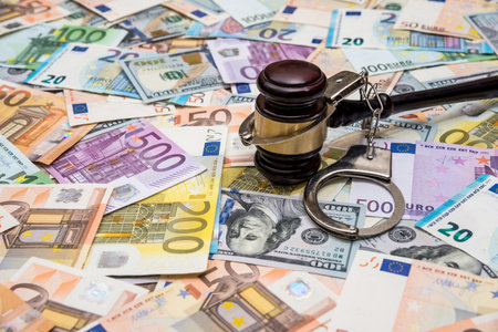 crime concept - handcuffs, gavel dollar and euro billsの写真素材