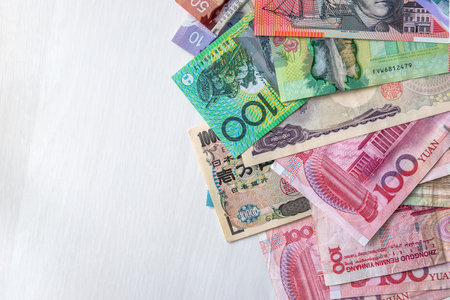 Mix of world currencies on wooden background