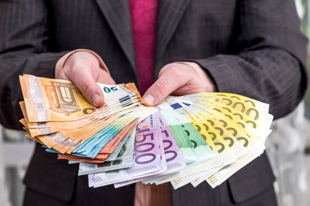 Businessman in suit with fan from euro banknotesの写真素材