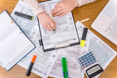 Woman filling 1040 individual tax form, office workの写真素材
