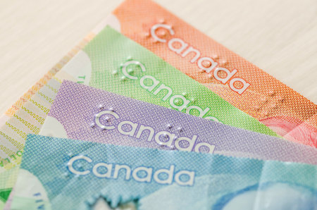 Colorful canadian dollar banknotes on wooden background