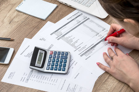 Woman counting her budget, hands with calculatorの写真素材
