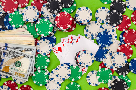 Playing cards with chips and money on green background