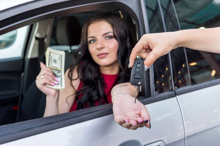 Woman receiving keys from a new carの写真素材