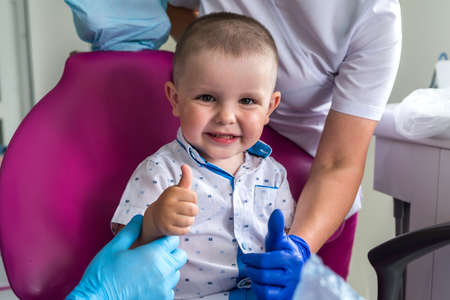 Little boy in dentistry smiling and showing thumb upの写真素材