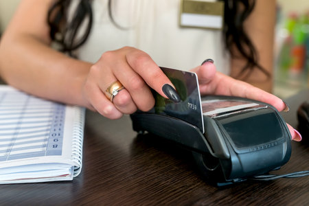 Female hands with credit card and terminalの写真素材