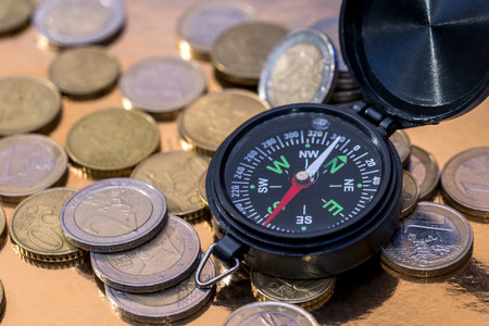euro coin and compass. Concept for financial direction