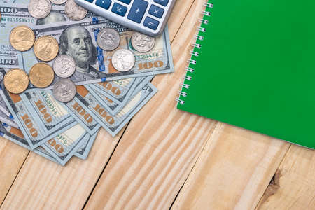 dollar bills and coin with calculator pen on desk