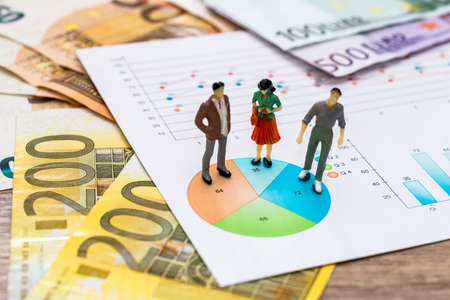 Small toys people discuss the graph and euroの写真素材