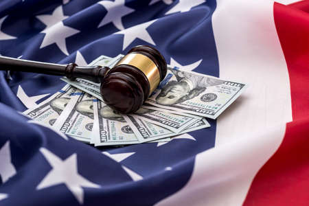 100-dollar bills and a hammer of judges placed on the American flag.