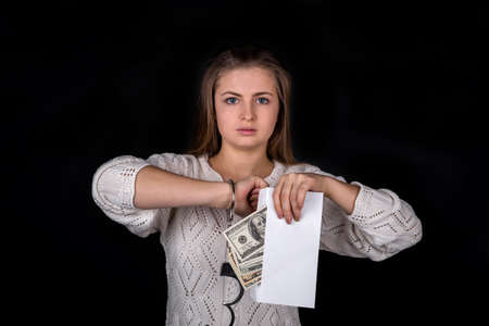 Unlocked handcuffs on woman with envelope, isolated on black