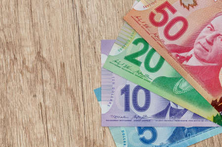 canadian dollar on wooden table close up