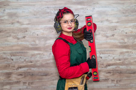 Woman with level measurement at wooden background