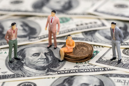 small toy people on american coin and banknotesの写真素材
