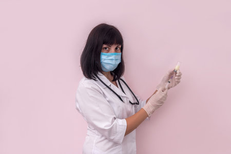 Doctor filling syringe for injection isolated on pinkの写真素材