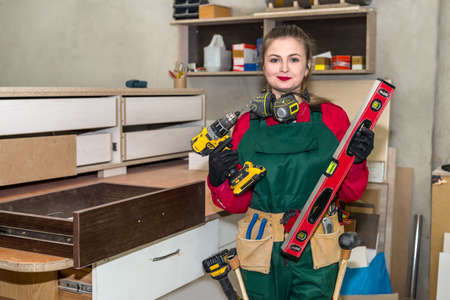 Woman carpenter with different tools in carpentry