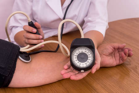 Female hands with tonometer measuring blood pressure