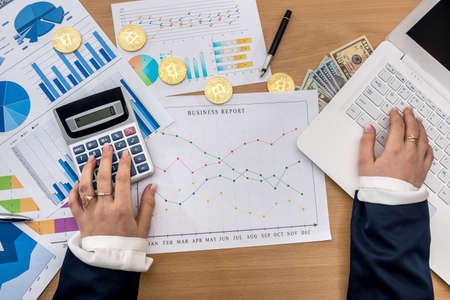 woman working at office - bitcoin business graph laptop and dollar