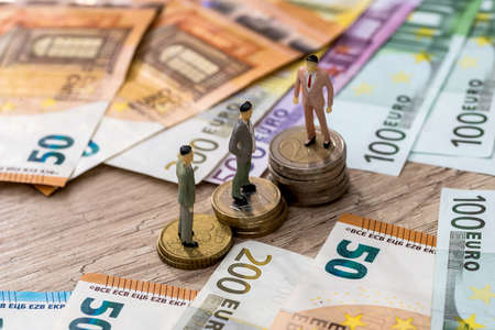 small toys people find on euro coins and near euroの写真素材