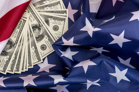 Hundred dollar bills are located on the American flag.