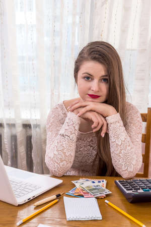 Thinking woman analyzing her profit in euroの写真素材