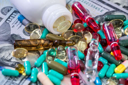 Colorful tablets with ampoules on dollar banknotesの写真素材
