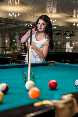 Woman with cue on bridge going hit a ball