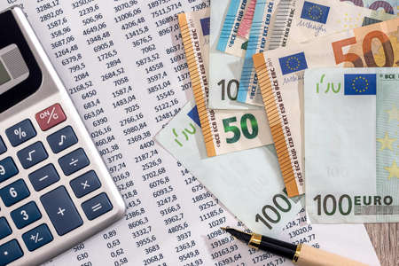Euro banknotes with calculator and pen on bank account statementの写真素材
