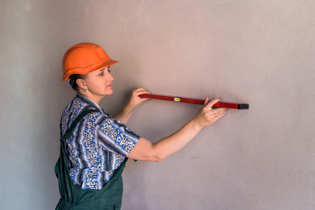 Beautiful woman builder working with water level