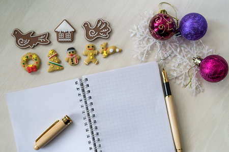 Notebook with gingerbread and pen on wooden tableの写真素材