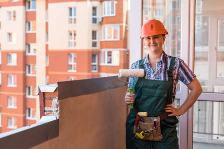 Woman with roller posing in protective uniformの写真素材