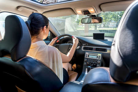 Beautiful woman inside car holding steering wheelの写真素材