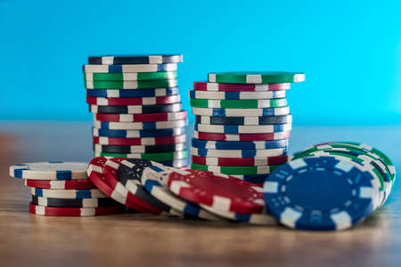 Casino chips on wooden table with blue background