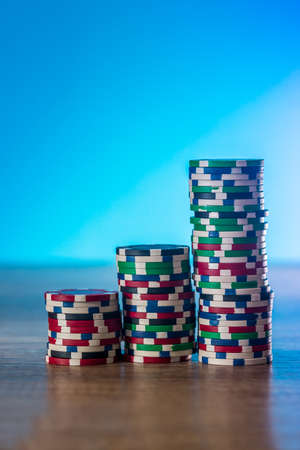Poker chips in stack on blue backgroundの写真素材