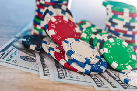 Dollar banknotes on wooden table with casino chipsの写真素材