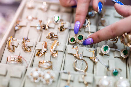 Female hands showing golden ring on jewelry collectionの写真素材