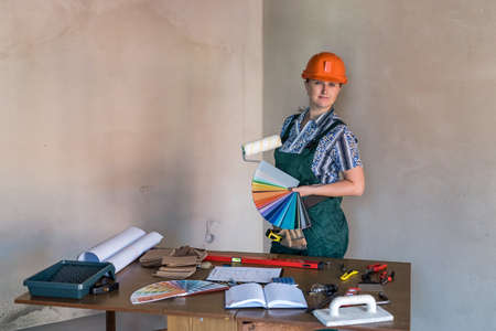 Woman in protective uniform showing painting tools