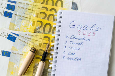 Notepad with 2019 goals and euro banknotes on tableの写真素材