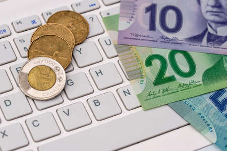 Canadian dollar with laptop - business conceptの写真素材