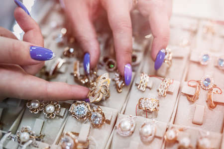 Female hands with golden jewelery in shop close upの写真素材