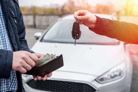 Hands exchanging with car keys and euro banknotes