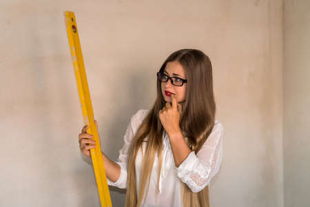 Portrait of worried woman holding water level tool