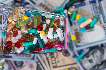 Top view of colorful tablets in cart on dollars backgroundの写真素材