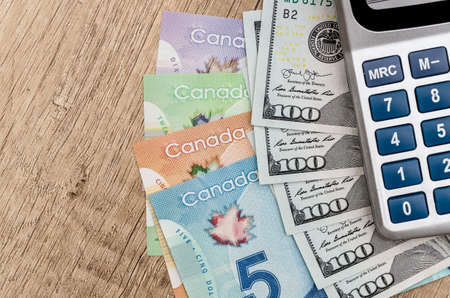 calculator with dollar usd and cad on deskの写真素材