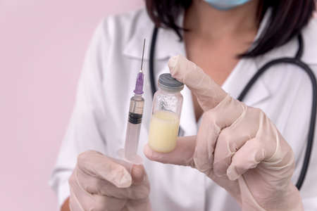 Syringe and ampoule with medicament in doctor's handsの写真素材