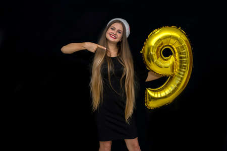 Woman posing with golden air balloon in studio